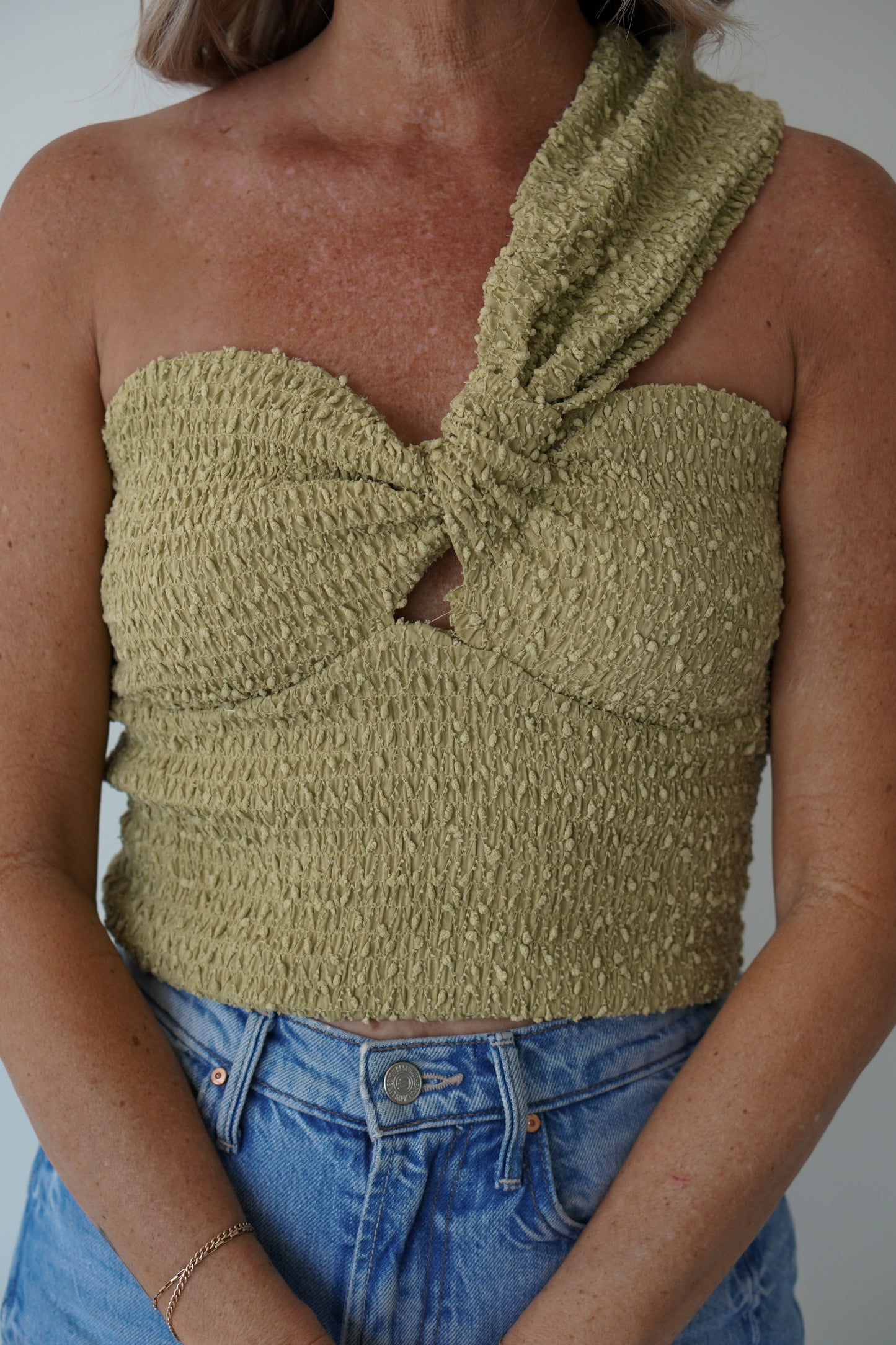 Lime green one shoulder top with high waisted jeans