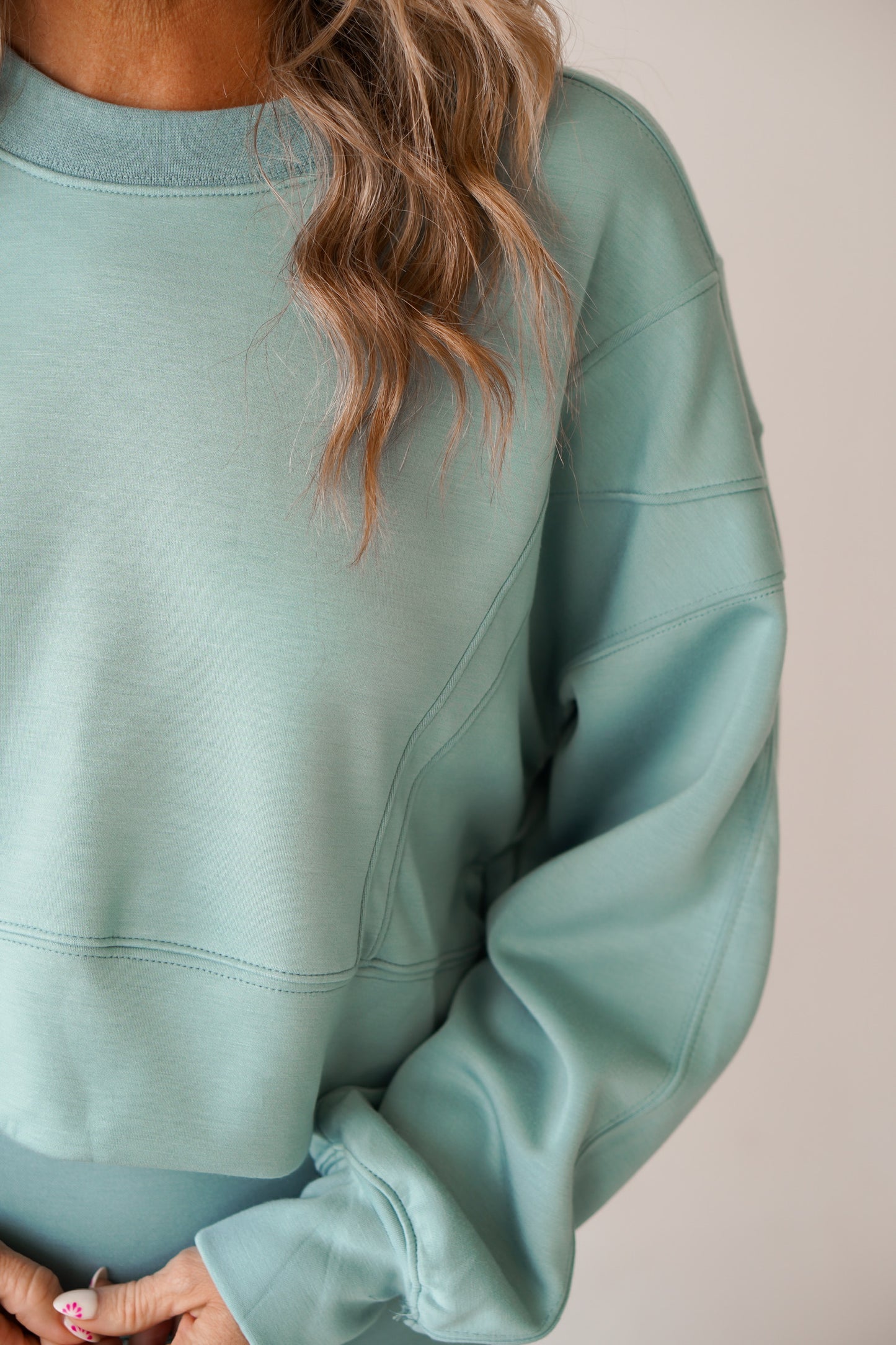 Women showing off the side of the sweatshirt to the set.