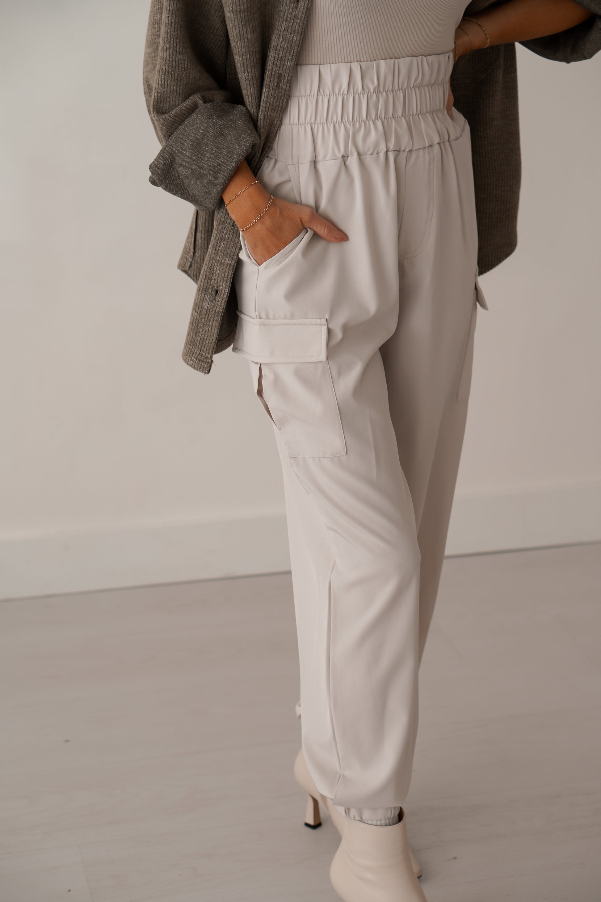 Up close of cream cargo joggers with her hand in pocket. 