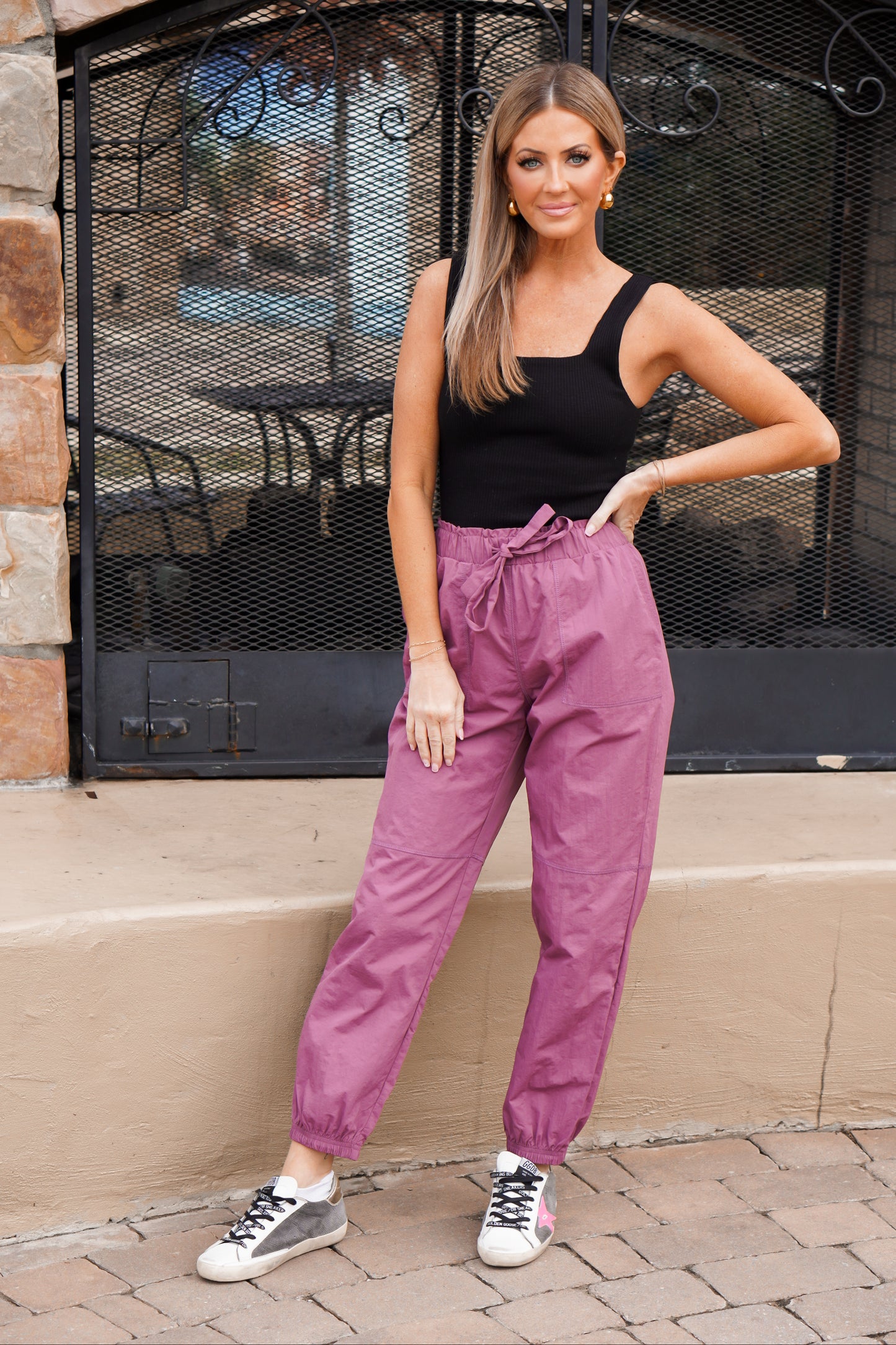 girl wearing black ribbed bodysuit with paper bag detailing joggers 