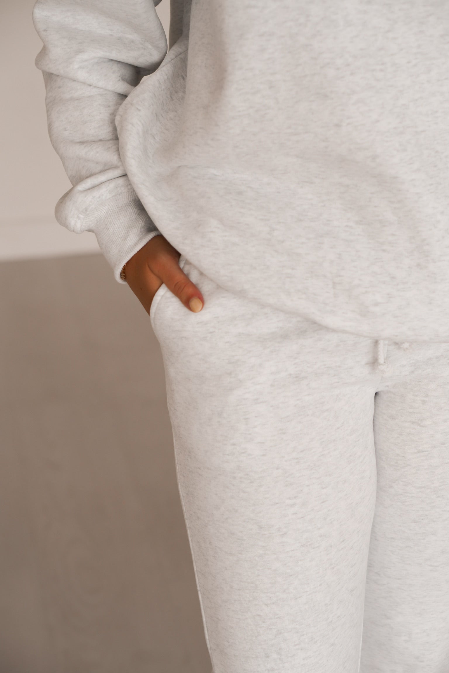 Showing that the grey sweatpants have pockets on the front