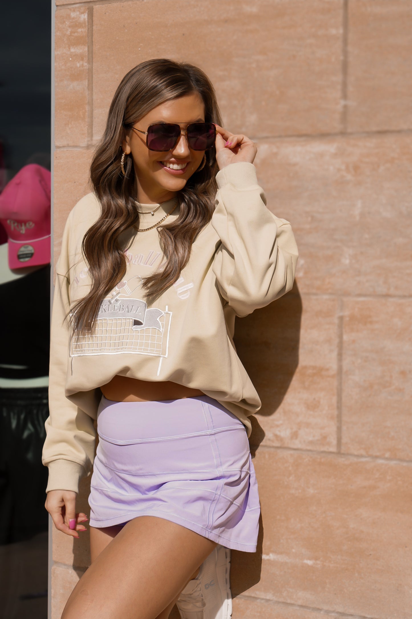 girl wearing sunglasses in our pickleball sweatshirt with tennis skirt