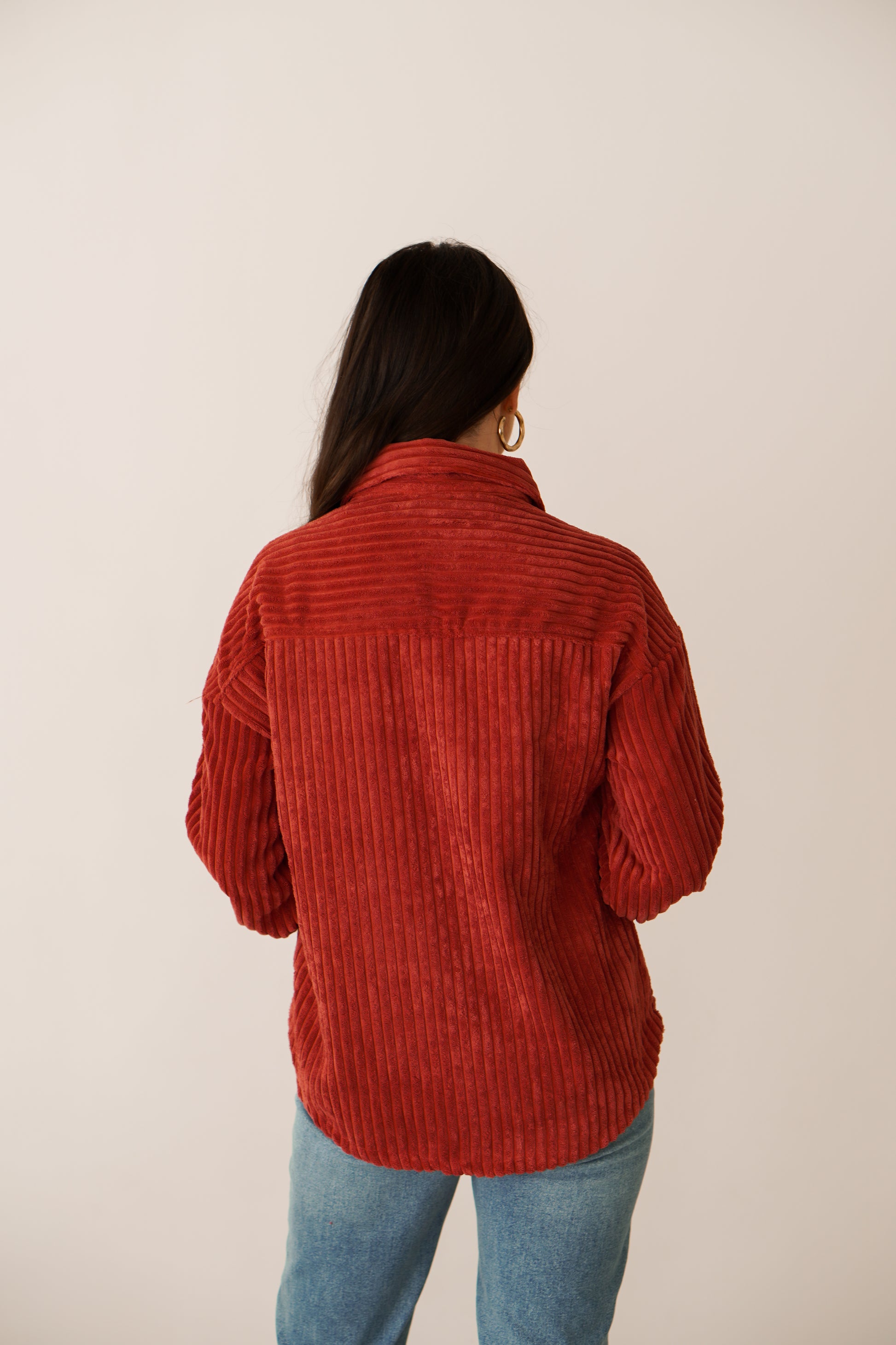 Brunette showing off the back of the rust color shacket. I