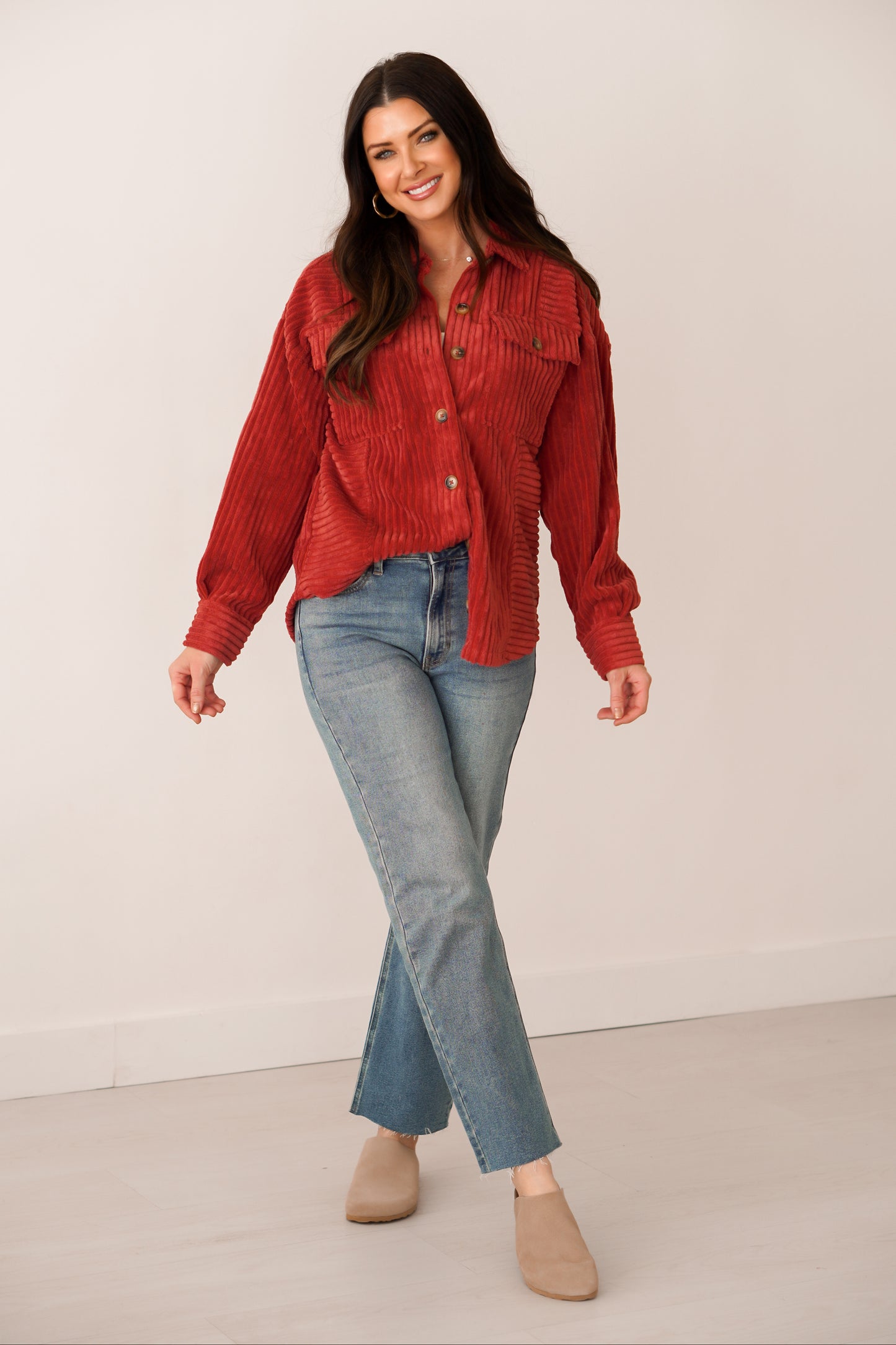 Brunette girl in a rust color shacket with brown buttons. 