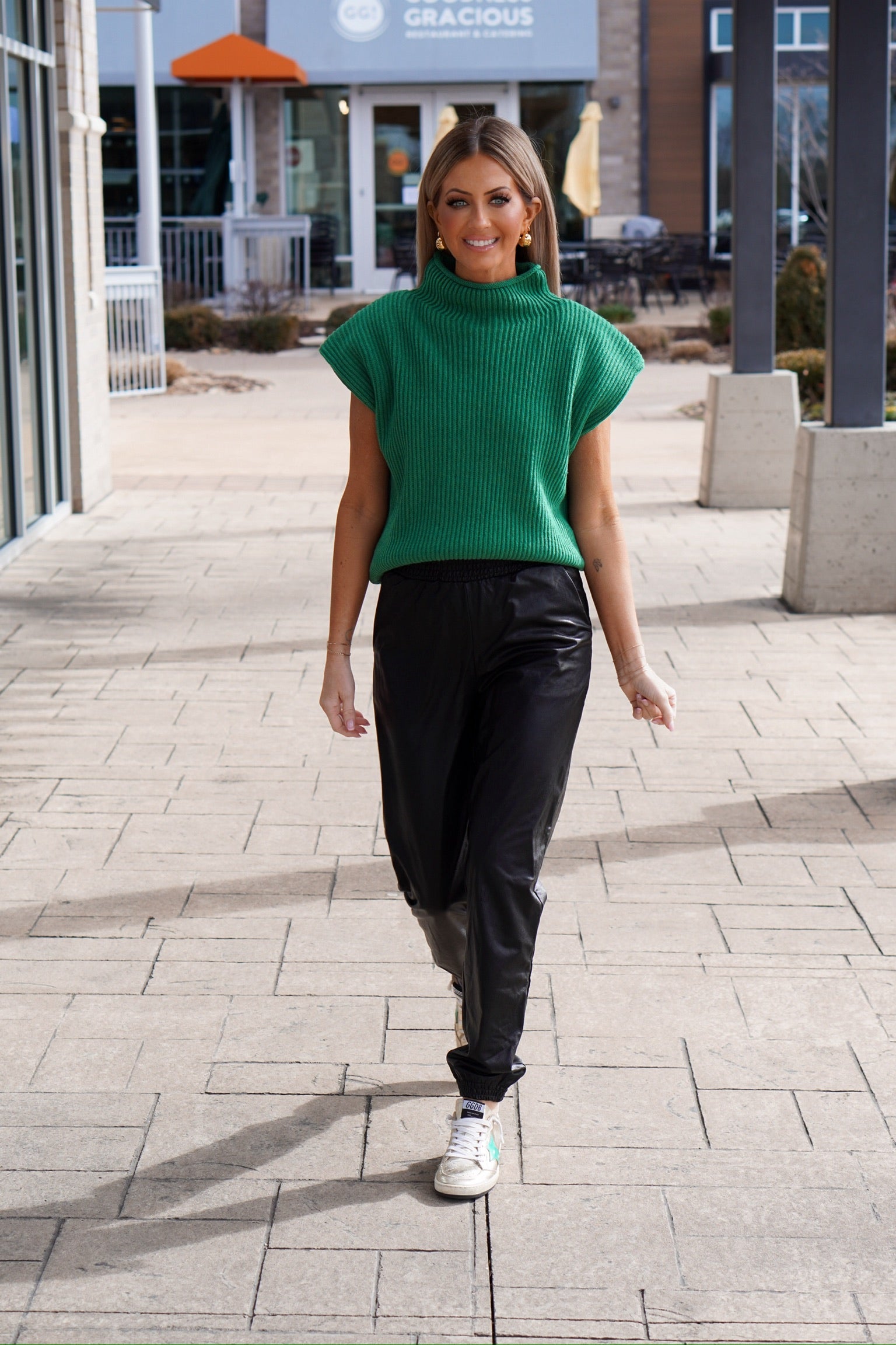 girl walking towards camera in Kelly green sweater vest 